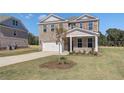 Two-story brick home with a white garage door and landscaping at 112 Dalston Cv, Stockbridge, GA 30281