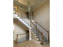 Elegant wooden staircase with a chandelier and hardwood floors at 4365 Miners Creek Rd, Lithonia, GA 30038