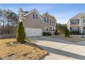 Two-story brick home with stone accents, three-car garage, and manicured lawn at 2007 Hamilton Lake Ct, Buford, GA 30519