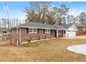 Brick ranch house with a two-car garage and landscaped yard at 1283 Woodleigh Sw Rd, Marietta, GA 30008