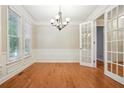 Formal dining room with hardwood floors, chandelier, and wainscoting at 6650 Fairgreen Dr, Suwanee, GA 30024