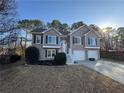 Two-story house with gray siding, double garage, and landscaped yard at 5106 Thorin Oak Cir, Sugar Hill, GA 30518