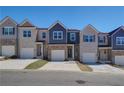 Row of townhouses featuring attached garages and neutral brick at 7012 Fringe Flower Dr # 87, Austell, GA 30168