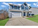 Two-story house with blue siding, white garage door, and driveway at 6025 Crescent Landing Dr, Cumming, GA 30028