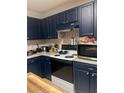 Kitchen with dark blue cabinets, white appliances, and granite countertops at 15 Winterville Dr, Rockmart, GA 30153