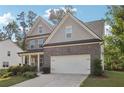 Two-story house with gray siding, brick accents, and a two-car garage at 6235 Banyan Trl, Cumming, GA 30028