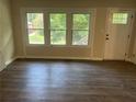 Bright living room with wood-look flooring and large windows at 1303 Rocksprings St, Forest Park, GA 30297