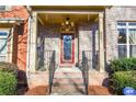 Inviting front porch with brick columns and a red front door at 6161 Thorncrest Dr, Tucker, GA 30084