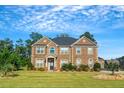 Two story brick home with large windows and landscaped yard at 4580 Cloister Cir, Hampton, GA 30228