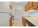 Galley kitchen with wood cabinets and white appliances at 300 Johnson Ferry Ne Rd # B413, Atlanta, GA 30328