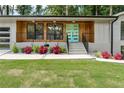 Mid-century modern home with a teal door and landscaped front yard at 3011 Belingham Ne Dr, Atlanta, GA 30345