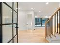 Bright and airy entryway with modern glass door and hardwood floors at 1240 Spalding Dr, Sandy Springs, GA 30350