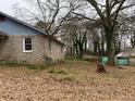 Side view of the house showing the brick exterior and landscaping at 4451 Flat Shoals Pkwy, Decatur, GA 30034