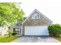 Stone and wood exterior with a white two-car garage at 2545 Lake Royale Dr, Riverdale, GA 30296