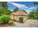 Two-car garage with a brick facade and a paved driveway at 490 Revenna Trl, Fayetteville, GA 30214