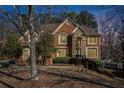 Brick house with a large front yard and mature trees at dusk at 585 Stoneglen Chase Sw, Atlanta, GA 30331