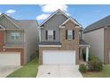 Two-story home with gray and brick exterior and a two-car garage at 3135 Hendrick Dr, Mcdonough, GA 30253