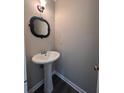 Small half bathroom with pedestal sink and dark mirror at 801 Hemingway Rd, Stone Mountain, GA 30088