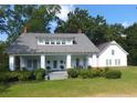 White farmhouse with wrap-around porch, landscaping, and detached garage at 788 S Hwy 11 S, Social Circle, GA 30025