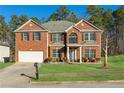 Two-story brick home with attached garage and landscaping at 3736 Busker Mill Ln, Ellenwood, GA 30294
