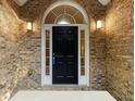 Front door entrance with a black door and arched window at 129 Talon Pl, Mcdonough, GA 30253