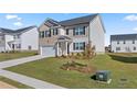 Two-story house with a brick and beige exterior, a two-car garage, and a landscaped lawn at 516 Vervain Drive, Locust Grove, GA 30248