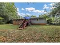 Home's back features a deck, stairs, and a spacious grassy yard at 3569 Briar Dr, Lithia Springs, GA 30122