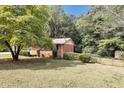 Large backyard with lush green grass, mature trees, and a shed at 3569 Briar Dr, Lithia Springs, GA 30122