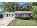 Ranch home with brick and gray siding, a small front yard, and mature trees at 3569 Briar Dr, Lithia Springs, GA 30122