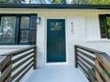 Modern dark green front door with wood accent railings at 970 Fairburn Nw Rd, Atlanta, GA 30331