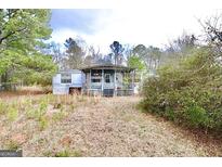 Mobile home with porch and overgrown yard at 1815 S Ola Rd, Locust Grove, GA 30248