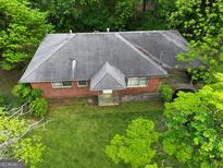 Brick house with gray roof, viewed from above, surrounded by lush green grass and trees at 00 Park Se Ave, Smyrna, GA 30080