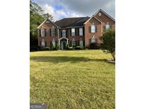 Brick two-story home with a well-manicured lawn at 2009 Town Square Dr, Mcdonough, GA 30253