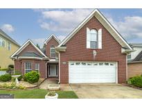 Two-story brick house with attached garage and landscaping at 129 Wexford Ct, Stockbridge, GA 30281