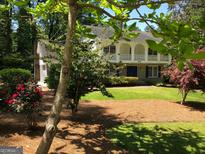 Two-story house with a large front yard, mature trees, and a long driveway at 2692 Peppermint Dr, Tucker, GA 30084