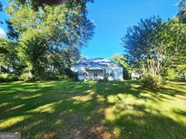 One story home with white siding, visible porch, and mature trees at 433 Mount Moriah Rd, Auburn, GA 30011