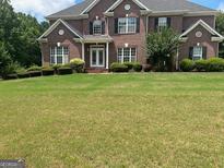 Brick house with a large front yard at 1221 Rhodes Sw Walk, Conyers, GA 30094
