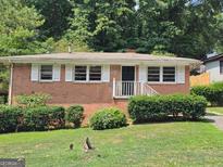 Brick ranch house with a well-maintained lawn and landscaping at 3436 Adkins Nw Rd, Atlanta, GA 30331