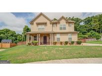 Two story house with tan siding and a large yard at 445 Brickstone Way, Covington, GA 30016