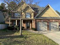 Two-story house with double garage and landscaping at 7495 St David St, Fairburn, GA 30213