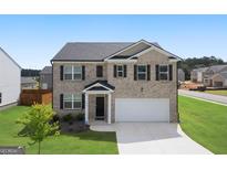Two-story brick home with a two-car garage at 104 Montgomery Dr, Stockbridge, GA 30281