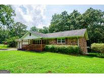 Brick ranch house with a carport and grassy yard at 489 Martin Rd, Stone Mountain, GA 30088