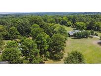Aerial view of house and expansive wooded lot at 1092 Harbins Rd, Dacula, GA 30019