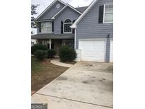 Two-story gray house with double garage and landscaping at 25 Franklin Way, Covington, GA 30016