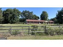 Brick ranch house with red roof, situated on a large lot at 175 Moss Dr, Mcdonough, GA 30252