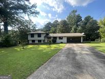 Ranch house with a brown garage door and a spacious lawn at 2101 Ann Se Ct, Conyers, GA 30013