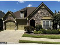 Stone and brick home with a two car garage and landscaping at 545 Grand Teton Cir, Fayetteville, GA 30215