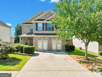 Brick two-story house with a three-car garage and manicured landscaping at 2319 Sawgrass Dr, Hampton, GA 30228