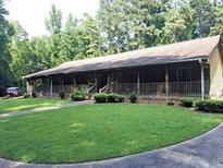 Ranch style home with long front porch and manicured lawn at 7505 Hall Rd, Fairburn, GA 30213