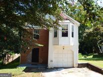 Two-story home with brick and white siding, and attached garage at 4999 Saxony Ct, Stone Mountain, GA 30083